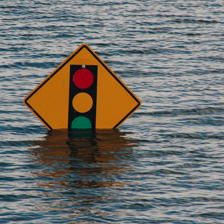 Photo of a street sign almost completely submerged in floodwater